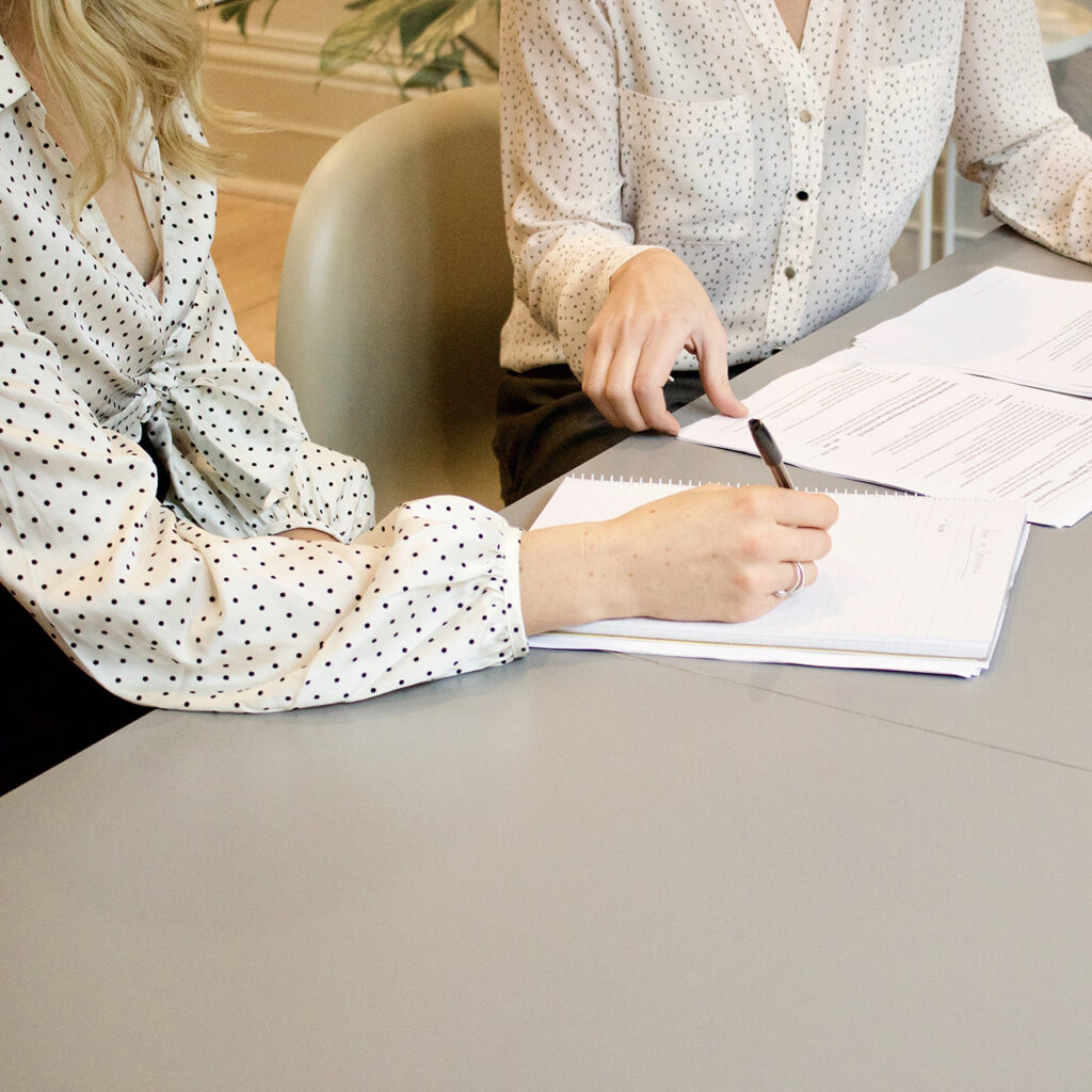 Two female coworkers reviewing papework